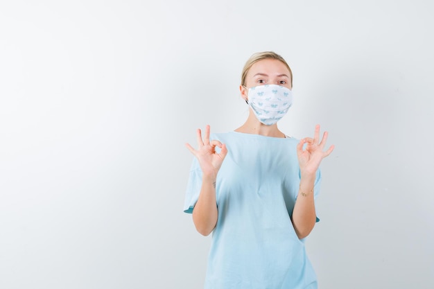 Jonge vrouw in een blauw t-shirt met een medisch masker