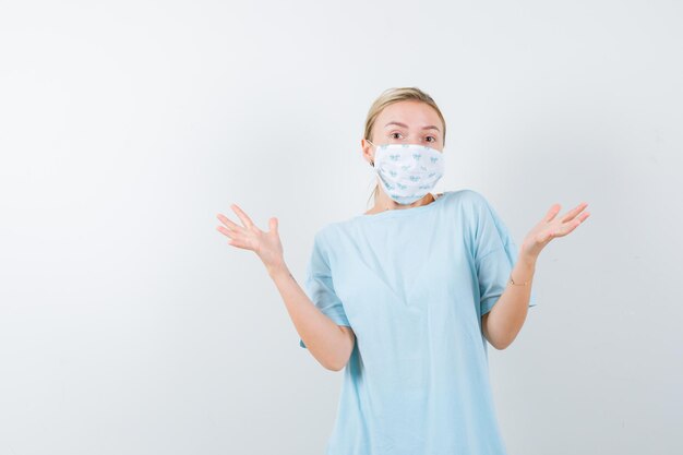 Jonge vrouw in een blauw t-shirt met een medisch masker