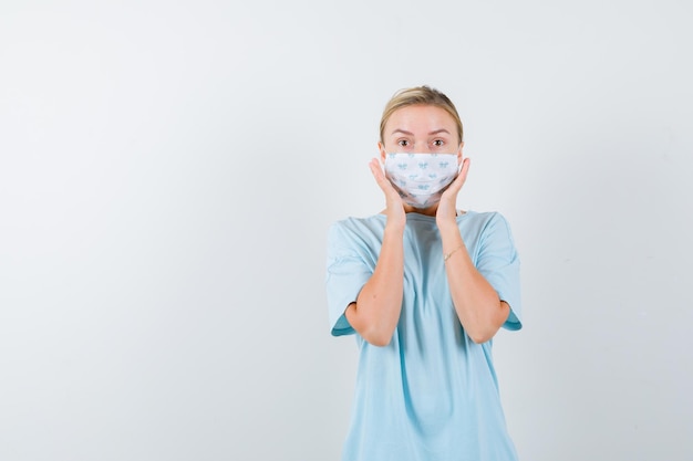 Gratis foto jonge vrouw in een blauw t-shirt met een medisch masker