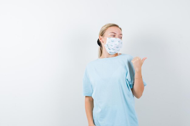 Jonge vrouw in een blauw t-shirt met een medisch masker