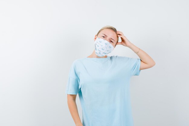 Jonge vrouw in een blauw t-shirt met een medisch masker