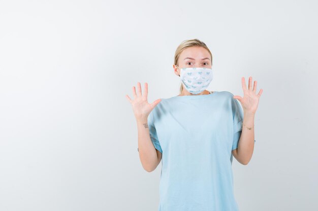 Jonge vrouw in een blauw t-shirt met een medisch masker