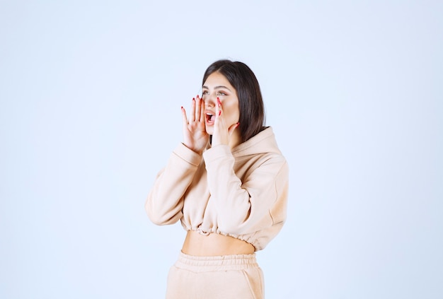 Jonge vrouw in een roze hoodie die hardop schiet