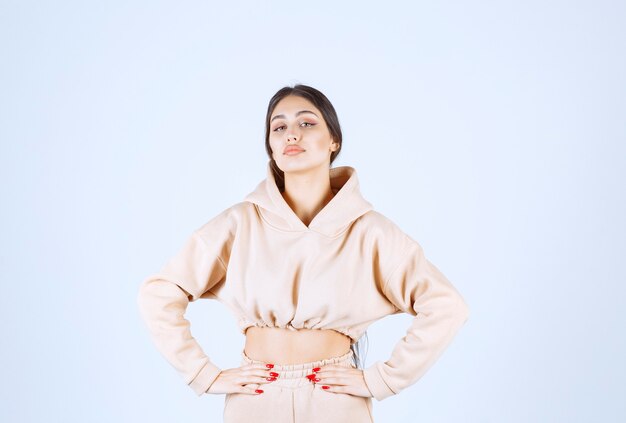 Jonge vrouw in een roze hoodie die neutrale poses geeft