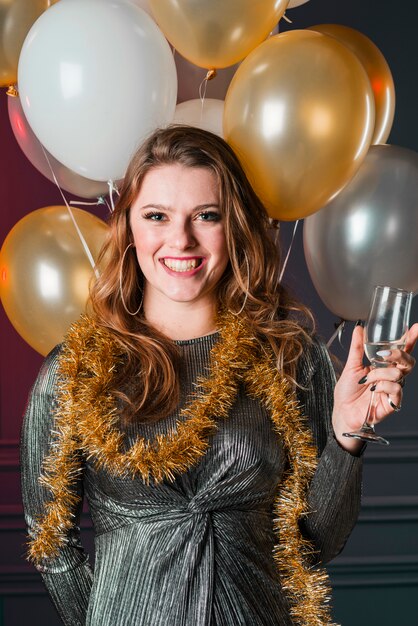 Jonge vrouw in grijze jurk met champagneglas