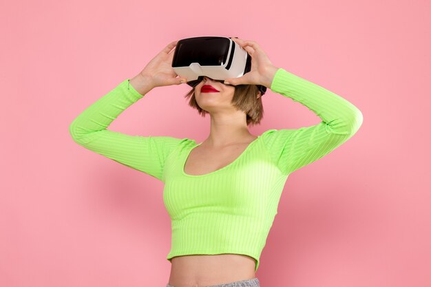 jonge vrouw in groen shirt en grijze broek virtual reality-spel uitproberen