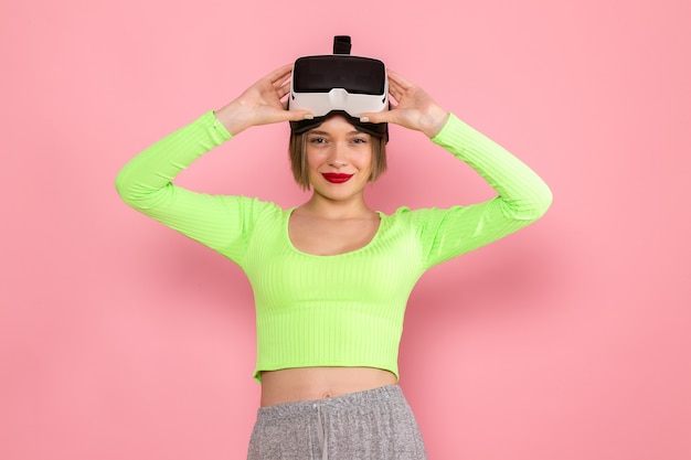 jonge vrouw in groen shirt en grijze rok glimlachend uitproberen van virtual reality