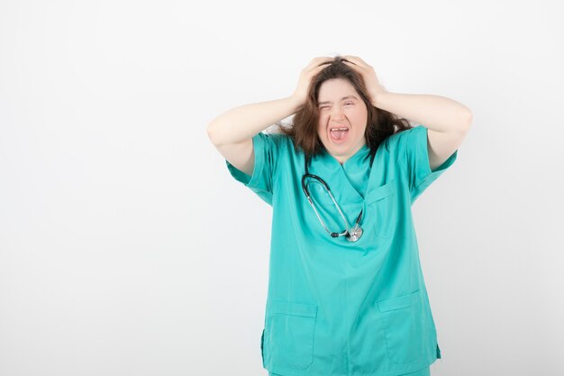 jonge vrouw in groen uniform staan en poseren.