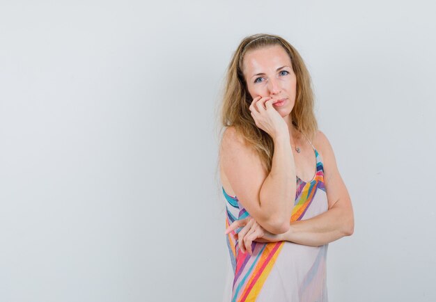 Jonge vrouw in het denken pose in zomerjurk en op zoek verstandig