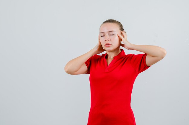 Jonge vrouw in rode t-shirt hand in hand en kijkt moe