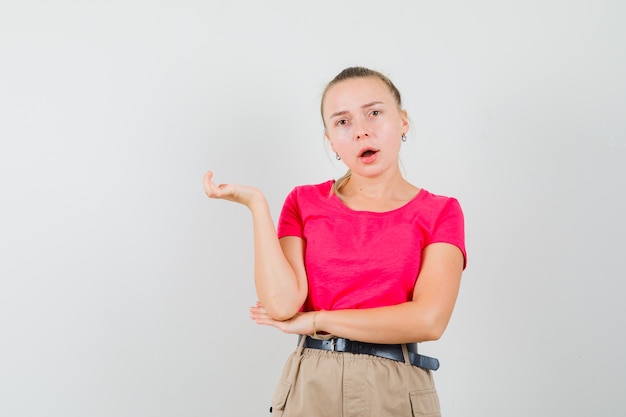 Jonge vrouw in t-shirt en broek en op zoek verward