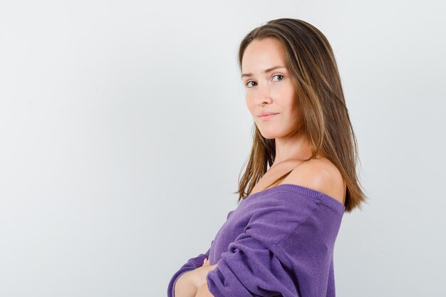 Jonge vrouw in violet overhemd camera kijken en verstandig kijken.