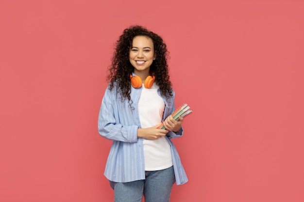 Gratis foto jonge vrouw in vrijetijdskleding op roze achtergrond