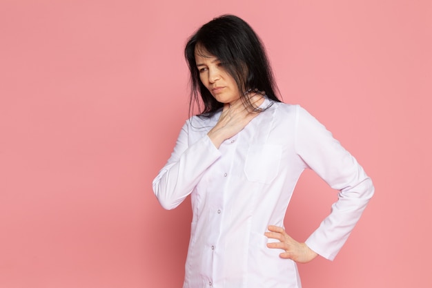 jonge vrouw in witte medische pak met ademhalingsproblemen op roze