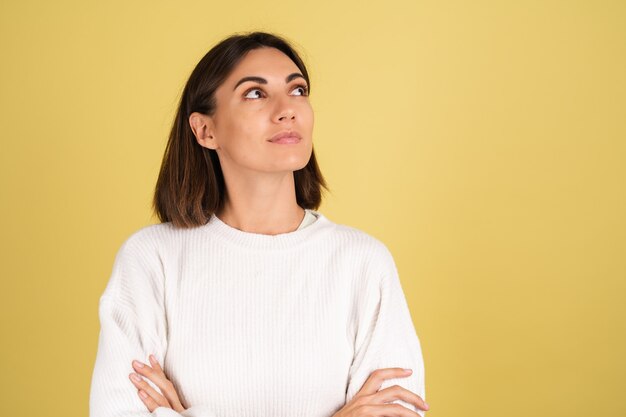 Jonge vrouw in witte warme trui attent met glimlach