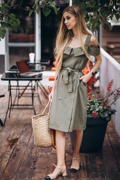 Gratis foto jonge vrouw in zomer outfit buiten café