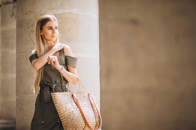 Jonge vrouw in zomer outfit door een oud gebouw