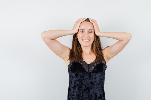 Jonge vrouw in zwart hemd hand in hand op het hoofd en op zoek zalig