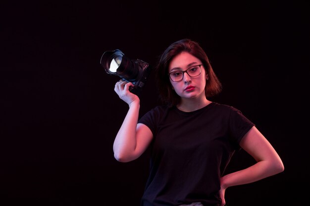 Jonge vrouw in zwart t-shirt met camera