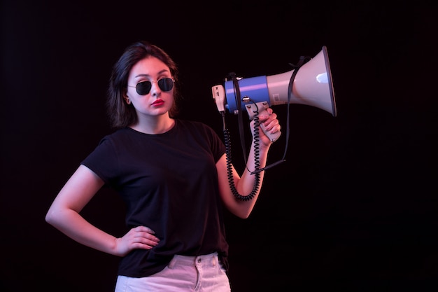 Jonge vrouw in zwarte t-shirt met megafoon