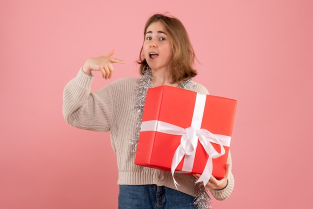 jonge vrouw kerst aanwezig in haar handen op roze te houden