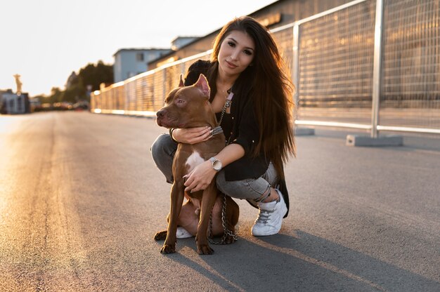 Jonge vrouw knuffelt haar pitbull