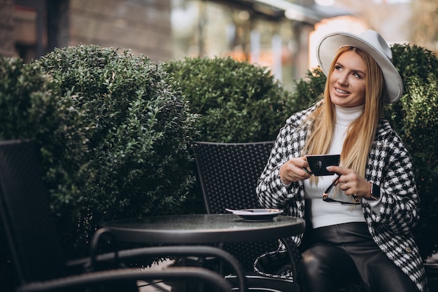 Jonge vrouw koffie drinken in een café