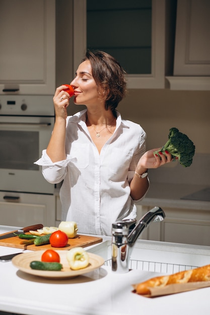 Jonge vrouw koken in de keuken in de ochtend