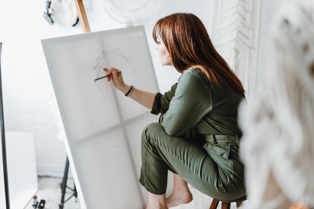 Jonge vrouw kunstenaar tekenen schilderij in studio