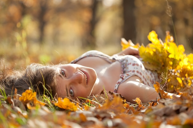 Jonge vrouw ligt in de herfstpark