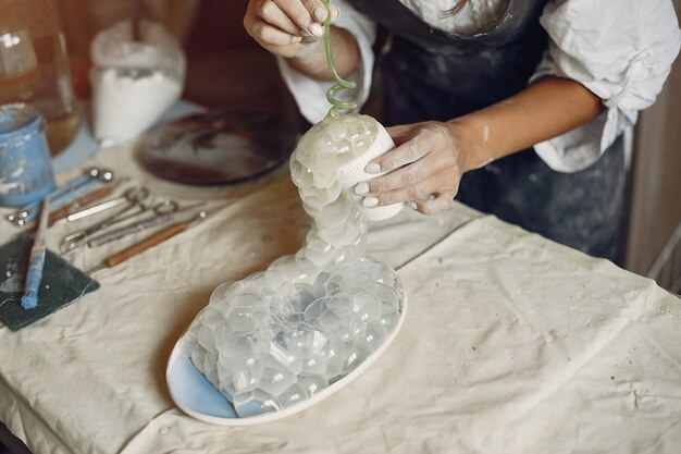 Jonge vrouw maakt aardewerk in werkplaats