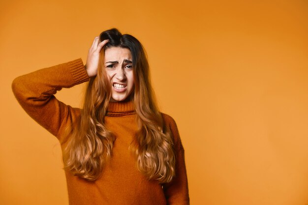 Jonge vrouw maakt zich zorgen en houdt één hand op haar hoofd