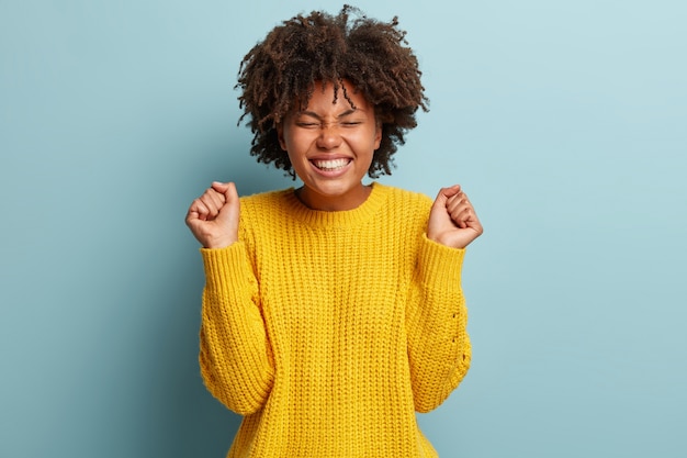 Jonge vrouw met Afro kapsel die een trui draagt