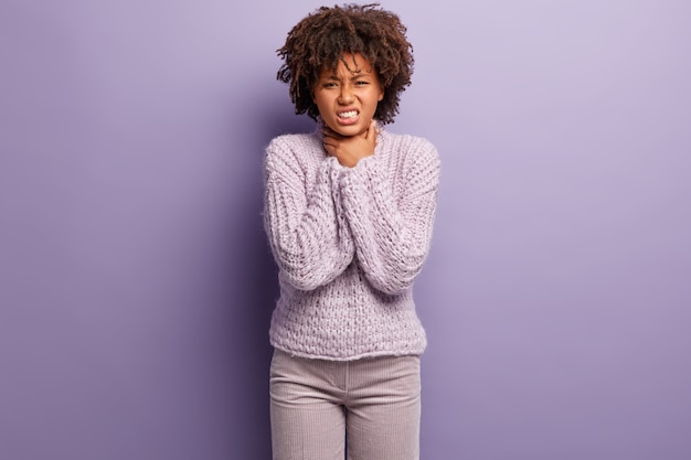 Jonge vrouw met Afro-kapsel die paarse trui draagt