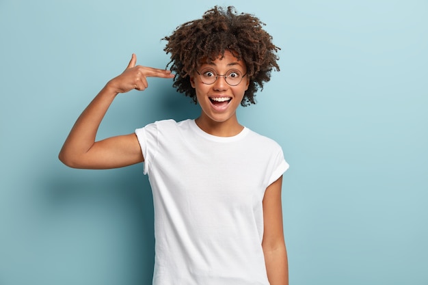 Jonge vrouw met Afro-kapsel, gekleed in wit T-shirt