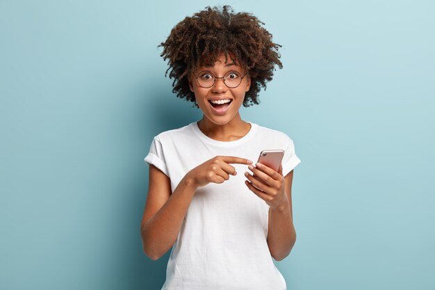 Jonge vrouw met Afro-kapsel, gekleed in wit T-shirt