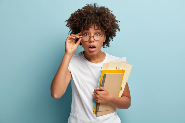 Jonge vrouw met Afro-kapsel, gekleed in wit T-shirt