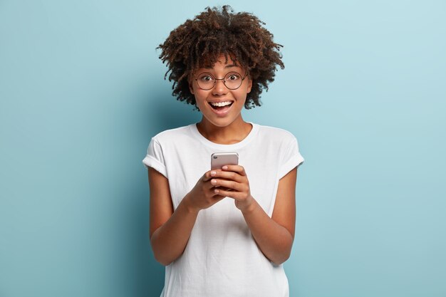 Jonge vrouw met Afro-kapsel, gekleed in wit T-shirt