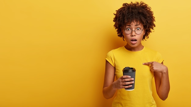 Jonge vrouw met Afro kapsel kopje koffie te houden