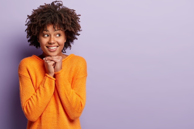 Jonge vrouw met Afro kapsel oranje trui dragen