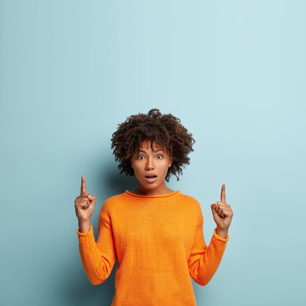 Jonge vrouw met Afro kapsel trui dragen