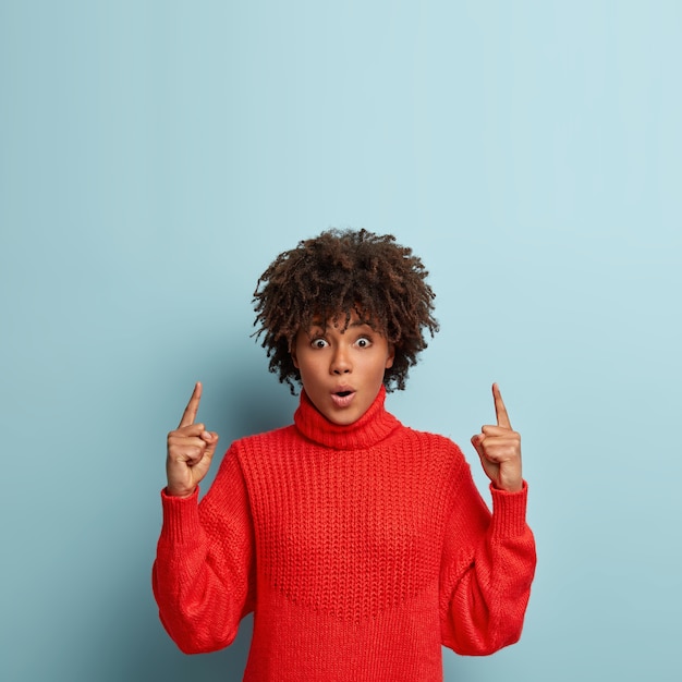 Jonge vrouw met Afro kapsel trui dragen