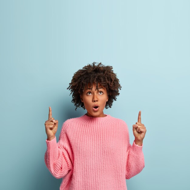 Jonge vrouw met Afro kapsel trui dragen