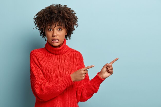 Jonge vrouw met Afro kapsel trui dragen