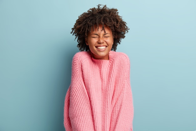 Jonge vrouw met Afro kapsel trui dragen