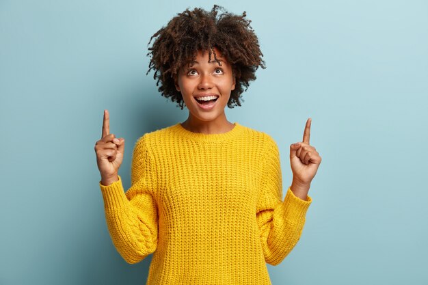 Jonge vrouw met Afro kapsel trui dragen