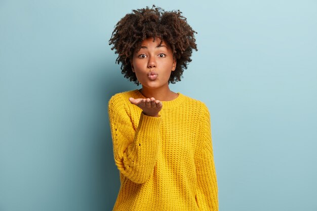 Jonge vrouw met Afro kapsel trui dragen