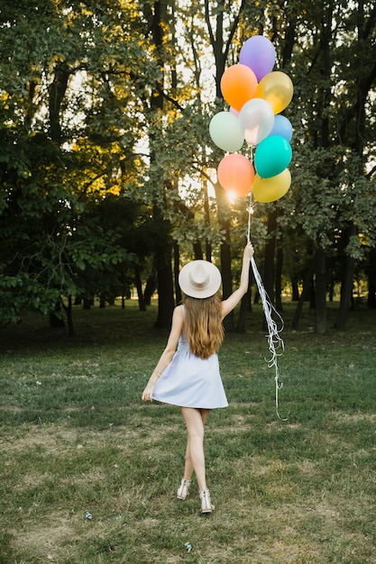 Jonge vrouw met ballonnen buiten