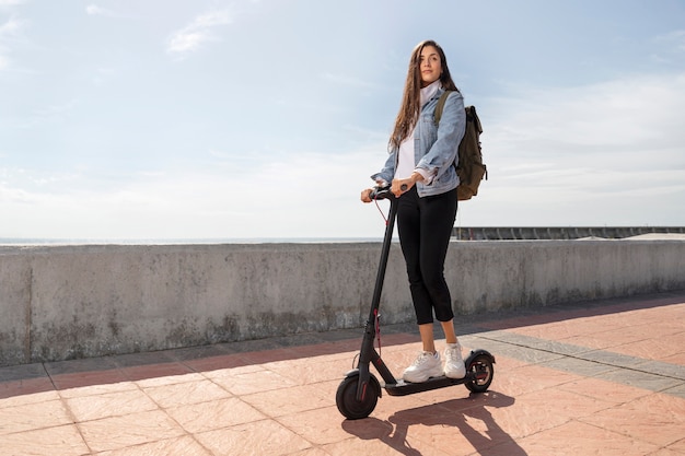 Jonge vrouw met behulp van een scooter buitenshuis