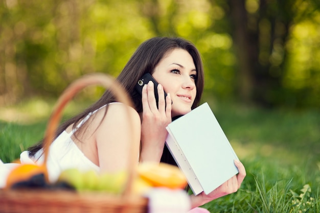 Jonge vrouw met behulp van een telefoon op de weide